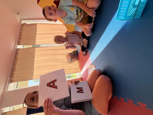 Lektorka vedie deti pri hravej aktivite s písmenami